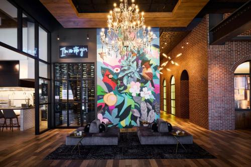 ein Wandgemälde an der Wand eines Restaurants mit zwei Tischen in der Unterkunft Archer Hotel Tysons in Tysons Corner
