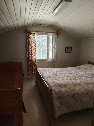 a bedroom with a large bed and a window at Lomakoti Tuulensuoja in Kärväsjärvi