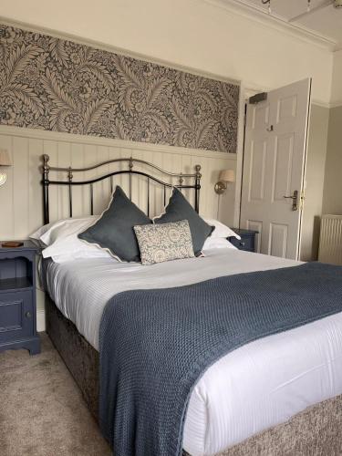 a bedroom with a large bed with a blue blanket at The Wylfa in Abersoch