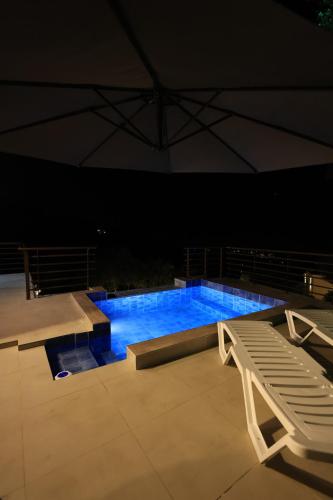 una grande piscina di notte con una panchina di Amaruna LB a Al Qarşā