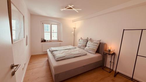 a white bedroom with a bed and a window at Cozy Corner - Passau in Passau