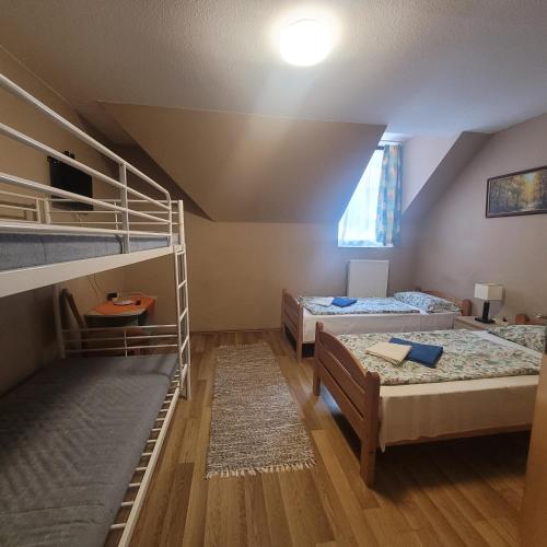a room with two bunk beds and a table at Ezüstfenyő Üdülő Visegrád in Visegrád