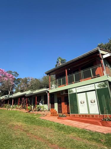 a building with a grass field in front of it at Iguazú Garden Lodge in Puerto Iguazú