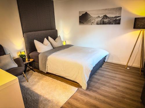 ein Schlafzimmer mit einem Bett und einem Stuhl in der Unterkunft SaaleLoft in Hirschberg
