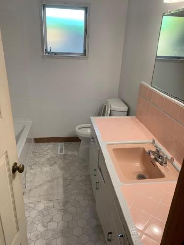 a bathroom with a sink and a toilet and a window at 4 Room Sleeps 8plus Tranquil Home in Santa Cruz