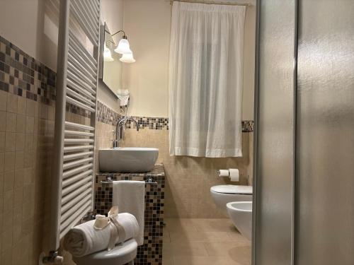 a bathroom with two toilets and a sink at Le Muse Hotel in San Bonifacio