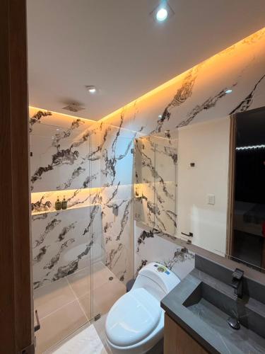 a bathroom with a toilet and a sink at Hotel Palmaris Urban Villeta in Villeta