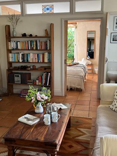 a living room with a coffee table and bookshelves at Pathways, Beachwood Cottage in Bath