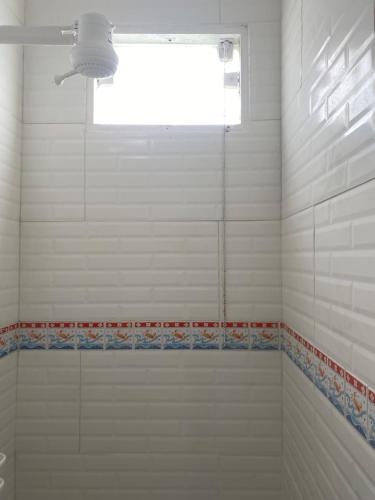 a bathroom with a shower with a window at Antonia Hospedaria 1 in Búzios