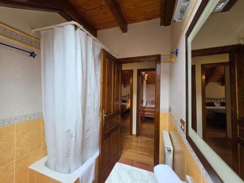 a bathroom with a white shower curtain in a room at El balcón de Cotefablo Chalet de Montaña con Jardín y Vistas - Arafita Apartamentos in Gavín