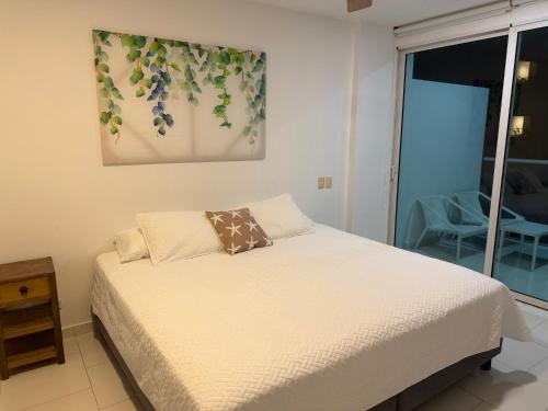 a bedroom with a bed and a painting on the wall at Edificio Morros 3 in Cartagena de Indias