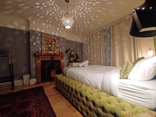 a bedroom with two beds and a couch with a fireplace at The Pearl Manor in Watford