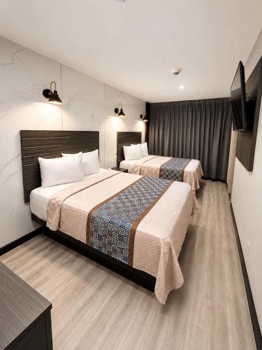 a hotel room with two beds and a flat screen tv at TREMONT HOTEL BRONx-GRAND OPENING in Bronx