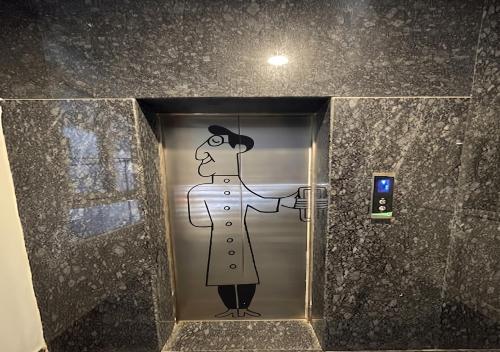 a painting of a man on the door of a elevator at Hotel A P S Townhouse in Prayagraj