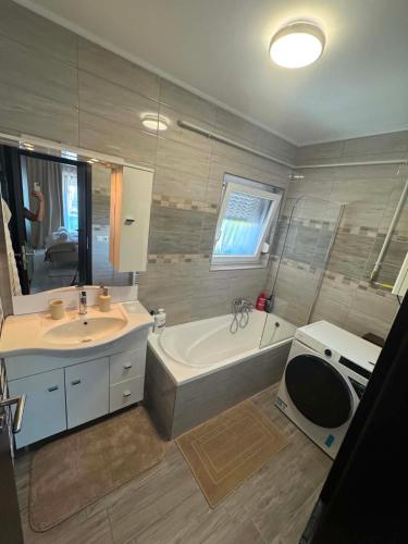 a bathroom with a tub and a sink and a bath tub at Luxiva Home in Nyíregyháza