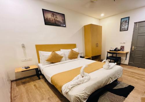 a bedroom with a large bed with towels on it at Hotel A P S Townhouse in Prayagraj