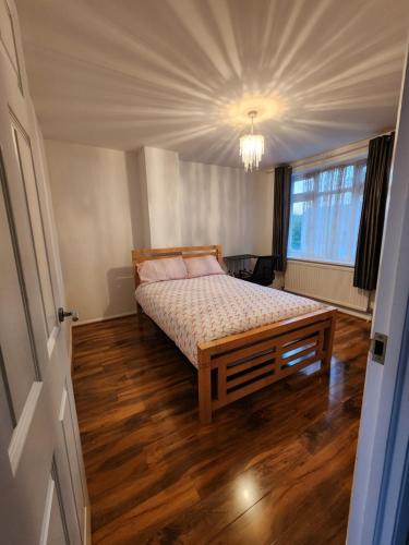 a bedroom with a bed with a wooden floor at The Willow in Aveley