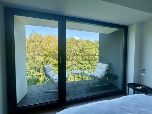 a bedroom with a view of a balcony with a table and chairs at Apartmán podlesí in Havířov