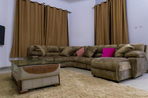 a living room with a brown couch and a table at Mwisongo Homestay in Morogoro