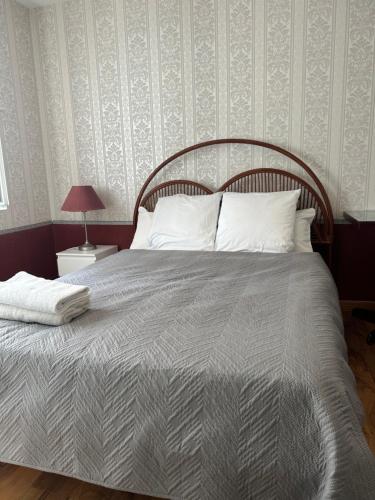 a bed with a wooden headboard in a bedroom at Maison calme à Beaune in Beaune