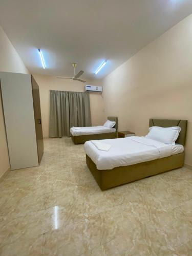 a hotel room with two beds and a window at الفردوس - RED14 Al-Firdous in Salalah