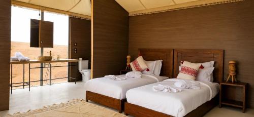 a bedroom with two beds with towels on them at Sunset Agafay Resort in El Karia