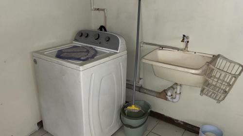 a kitchen with a washing machine and a sink at The Doctor's Quarters DQ in San Fernando