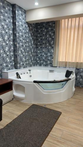 a white bath tub in a room with a rug at Hotel Residencial Paris in Arequipa