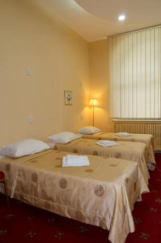 a room with three beds in a room with a window at Fortuna hostel in Odesa