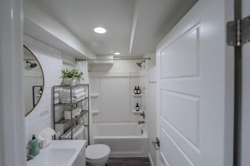 a white bathroom with a toilet and a shower at Modern Basement Apartment King Bed and Full Kitchen in Bluffdale