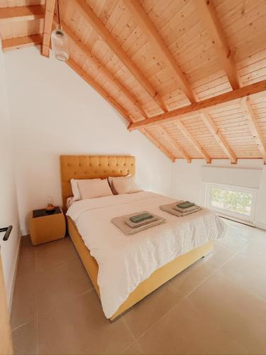a bedroom with a large bed with a wooden ceiling at PiuPiuStays in Vermelho