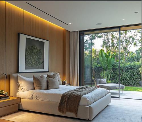 a bedroom with a large bed and a large window at The Roaring Pines in Dhikuli