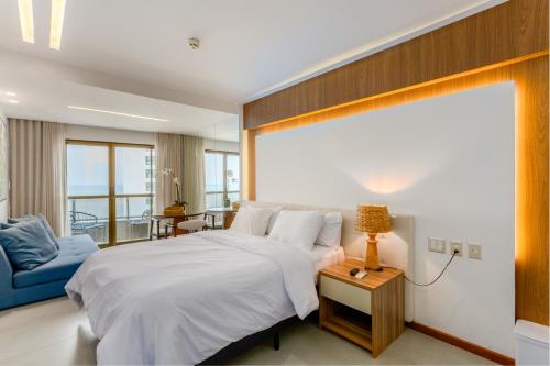 a bedroom with a large bed and a blue couch at HY Apartaments & Hotels-Boa Viagem in Recife