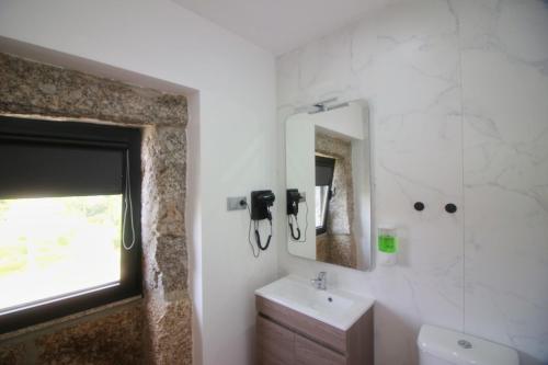 a bathroom with a sink and a mirror at Casa do Mestre by Gerês Casas in Geres