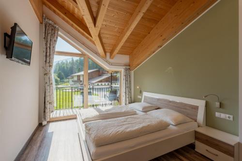 a bedroom with a bed and a large window at Unterbergerhof - Escape daily life - Enjoy nature - Explore more with activeCARD Sterzing in Val di Vizze