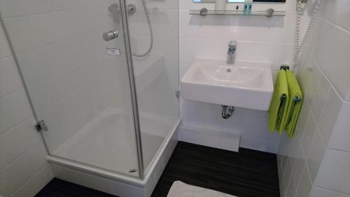 a bathroom with a sink and a shower at Hotel Deutschherrenhof in Trier