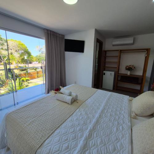 a bedroom with a large white bed and a large window at Pousada Sky Dream Beach Mutá Frente Mar By LVF in Porto Seguro