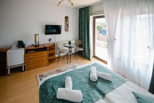 a bedroom with a bed with white towels on it at Casa Ienciu in Sibiu
