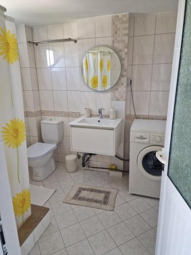 a bathroom with a sink and a washing machine at Villa Noah in Berat