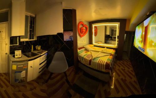 a bedroom with a bed and a sink and a television at Gold House Premium in Quito