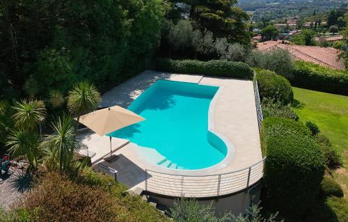 an overhead view of a swimming pool with an umbrella at Sunset Serenity Villa in Padenghe sul Garda