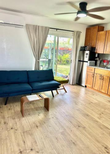 a living room with a blue couch and a table at Happy Hill Inn in Kailua-Kona