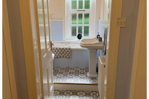 a bathroom with a sink and a bath tub at Largo Bay - Harbour Hideaway in Leven