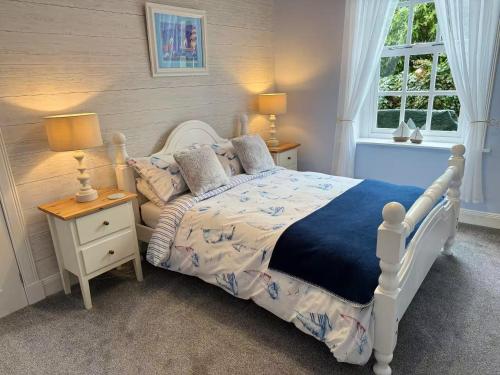 a bedroom with a white bed and two lamps and a window at Largo Bay - Harbour Hideaway in Leven