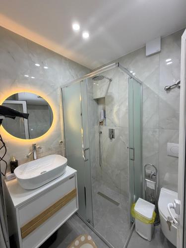 a bathroom with a sink and a shower at Lakefront House in Pogradec