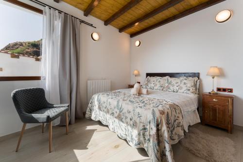 a bedroom with a bed and a chair and a window at Villa Amada in Vega de San Mateo