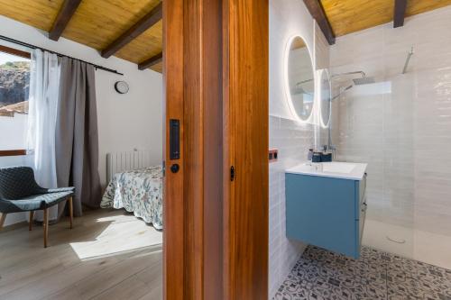 a bathroom with a sink and a room with a bed at Villa Amada in Vega de San Mateo