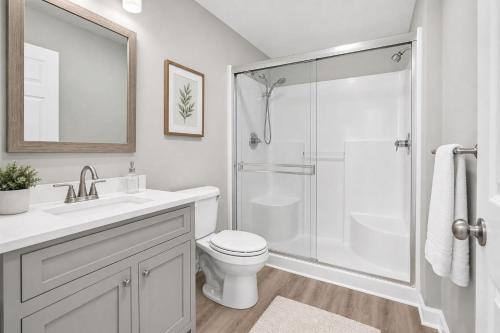 a white bathroom with a shower and a toilet at PINE AND TIMBER GETAWAY in Jackson