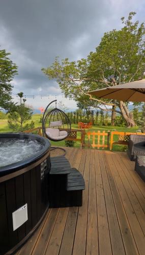 a deck with a hot tub and a swing at Villa Venus in Ferizaj