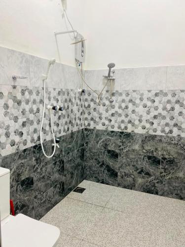 a shower in a bathroom with a tiled wall at The Royal Ember in Arugam Bay